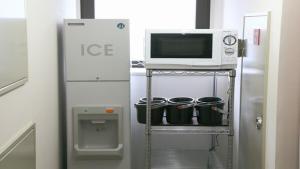 eine Mikrowelle auf einem Regal neben einem Kühlschrank in der Unterkunft HOTEL BRIGHT INN MORIOKA in Morioka