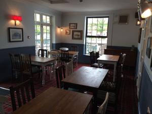a restaurant with wooden tables and chairs in a room at Dunstan House in Burnham on Sea