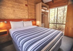 a bedroom with a large bed and a window at Bussells Bushland Cottages in Margaret River Town