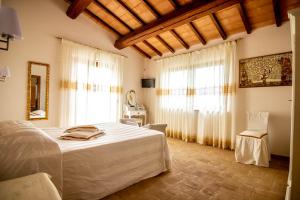 a bedroom with a bed and two windows at Casale Di Vulci in Case Riminino +69 photos