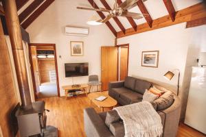 a living room with a couch and a tv at Bussells Bushland Cottages in Margaret River Town
