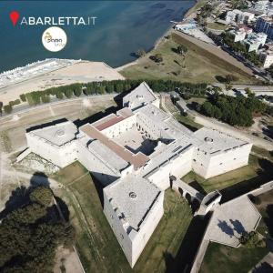 eine Luftansicht eines großen weißen Gebäudes neben dem Wasser in der Unterkunft B&B Dama3 in Barletta