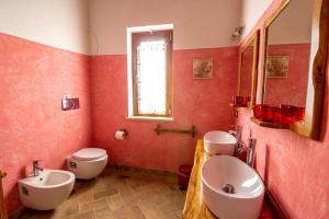 Case RimininoにあるCasale Di Vulciの赤いバスルーム(トイレ2つ、シンク付)