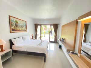 a bedroom with a large bed and a large window at Padang-Padang Sari Homestay in Uluwatu