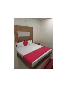 a bedroom with a bed with a red blanket at Hotel Atit Villa, Ujjain in Ujjain