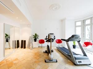 a gym with a treadmill and exercise equipment in a room at DORMERO Hotel Berlin Ku'damm in Berlin