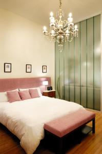 a bedroom with a large bed and a chandelier at Poetry Building Recoleta in Buenos Aires