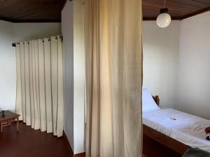 a bedroom with a bed and a window with curtains at WINGS HOTELS in Nosy Be