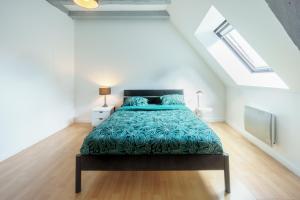 - une chambre mansardée avec un grand lit dans l'établissement Appartement dans le vieux Châteauroux, à Châteauroux