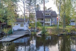 a house next to a body of water at Room by Lake 10 minutes from Tampere centrum in Lempäälä