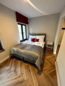 a bedroom with a bed and a wooden floor at Podgrzewany basen, sauna, nowy Revist Szklarska B7 in Szklarska Poręba