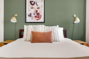 a bedroom with a white bed with two lamps at Loop 1BR w Gym Roofdeck nr Financial District CHI-201 in Chicago