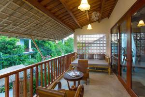 Habitación con balcón con mesa y sillas. en Vina Beach Pool Villas, en Hoi An