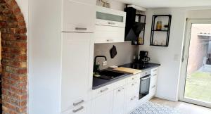 a kitchen with white cabinets and a black counter top at Modern Apartment Bedburg-Hau in Bedburg Hau