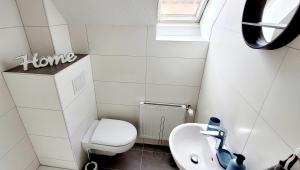 a small bathroom with a toilet and a sink at Modern Apartment Bedburg-Hau in Bedburg Hau +13 photos