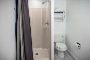 Kittery Inn & Suites في كيتري: حمام مع مرحاض أبيض ودش