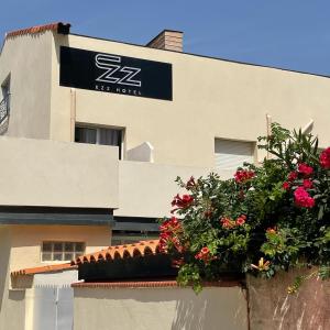 a building with a flower pot on the side of it at Ezz'Hotel Canet in Canet-en-Roussillon