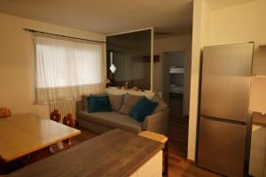 a kitchen and a living room with a couch at Casa Latemar in Moena