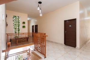 a hallway with a staircase and a brown door at Urbanview Hotel Nisura Homestay Medan by RedDoorz in Sunggal