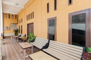 a room with benches and tables and a building at Urbanview Hotel Nisura Homestay Medan by RedDoorz in Sunggal