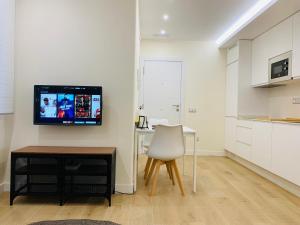 kuchnia z biurkiem i telewizorem na ścianie w obiekcie Alameda Lofts Pontevedra w mieście Pontevedra +7 zdjęć