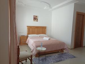 a bedroom with a bed and a table and a chair at Cozy duplex in Rabat