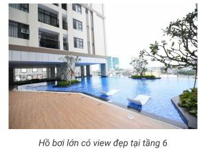 a large building with a swimming pool in front of it at Homestay căn hộ Mẹ Khang in Dĩ An
