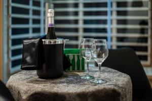 a bottle of wine and two wine glasses on a table at Terra Mia Suite in Catania