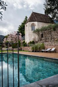 a house with a swimming pool in front of a building at Schloss Freudenstein in Appiano sulla Strada del Vino