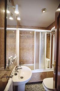 a bathroom with a sink and a tub and a toilet at Hostal Plaza in Ciudad-Rodrigo