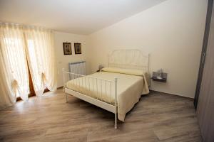 a bedroom with a white bed and a wooden floor at Casa Landi in Cetara