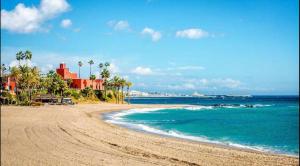 a sandy beach with palm trees and the ocean at BENALBEACH COMPLEX in Benalmádena