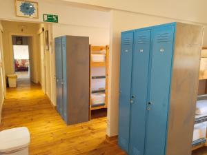 a room with three blue lockers and a hallway at Las Hadas Albergue Peregrinos - Atención personalizada in Reliegos