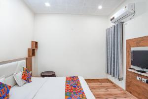 - une chambre avec un lit et une télévision dans l'établissement FabHotel Sirtaj Suites, à Agra