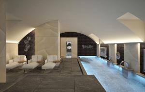 a swimming pool in a room with white chairs and tables at Palazzo Santo Spirito in Bergamo