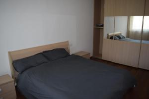 - une chambre avec un lit bleu et un miroir dans l'établissement Home d'elite Il Vitigno, à Lavis