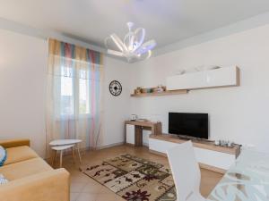 een woonkamer met een bank en een tv bij Domus Perrone Garden Blue & Yellow in Squinzano