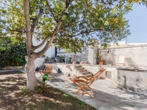 een patio met een boom, stoelen en een trap bij Domus Perrone Garden Blue & Yellow in Squinzano
