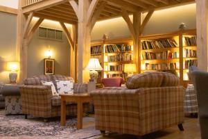 een woonkamer met 2 stoelen en boekenplanken bij The Fleece at Ruleholme in Carlisle