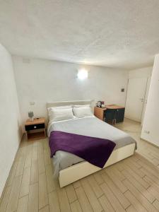 リオマッジョーレにあるMare Dentroのベッドルーム(紫の毛布を使用した大型ベッド1台付)