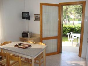 a dining room with a table and chairs and a door at Appartanenti Arcadia in Caorle +7 photos