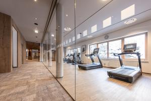 un gimnasio con cintas de correr y máquinas elípticas en Rieser Achensee Resort, en Pertisau