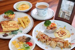 Alishan B&B YunMinGi في فنتشيهو: طاولة مع أطباق من الطعام وكوب من القهوة