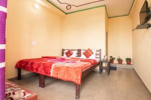 een slaapkamer met een bed met een rode sprei bij Shivom Home Stay Artola Jageshwar in Panuānaula
