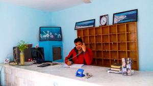 Octopus Hotel في دهب: رجل يجلس في مكتب يتحدث على الهاتف