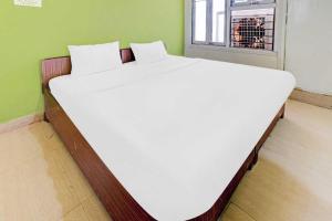 1 cama blanca grande en una habitación con ventana en SPOT ON Ganesh Guest House, en Gwalior