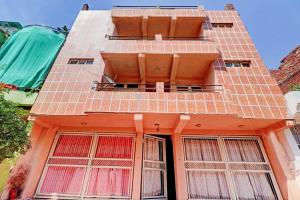 un edificio anaranjado con ventanas laterales en SPOT ON Ganesh Guest House, en Gwalior