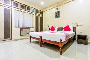 a bedroom with a large bed with red pillows at flagship heavens inn in Chennai