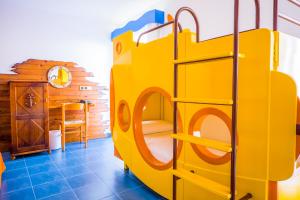 a yellow bunk bed in a room with blue tiles at Diverhotel Roquetas in Roquetas de Mar