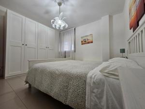 um quarto branco com uma cama e um lustre em B&B Interno 14 em Taranto